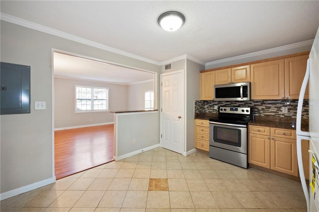 3665 Chestnut Drive, Unit D3 Atlanta, GA 30340 - Photo 10 of 16 a kitchen with granite countertop a stove a sink and a refrigerator