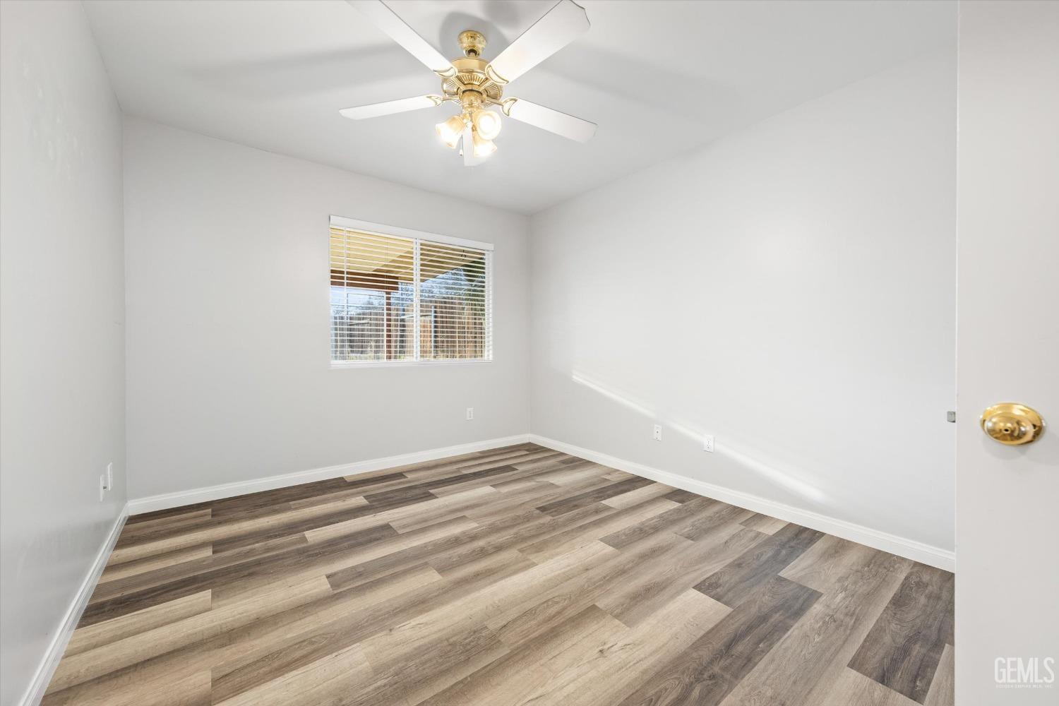 Undisclosed Address Bakersfield, CA 93308 - Photo 21 of 37 an empty room with a chandelier fan and windows