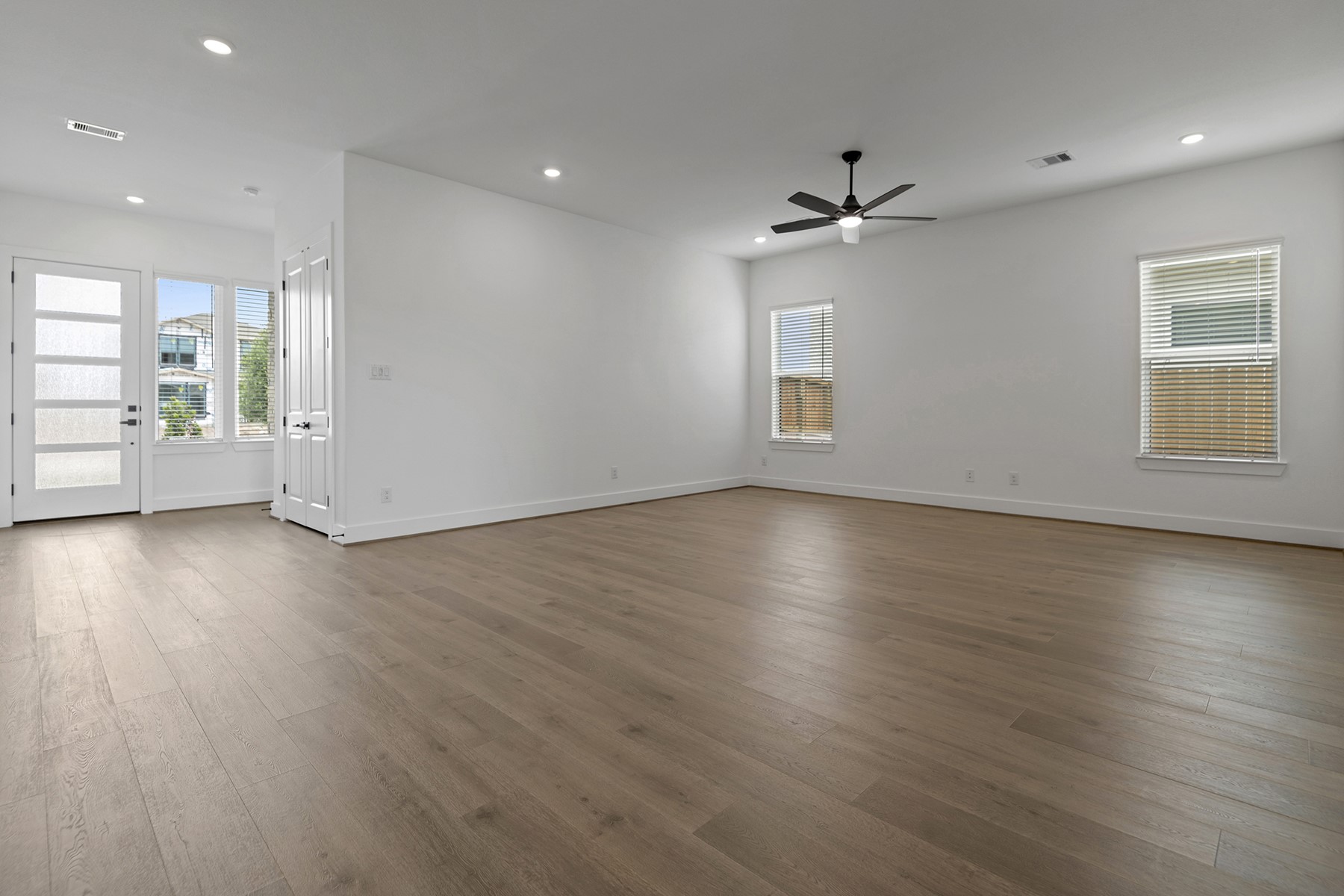 1911 Drover Lane Rosenberg, TX 77471 - Photo 4 of 22 an empty room with wooden floor a ceiling fan & windows