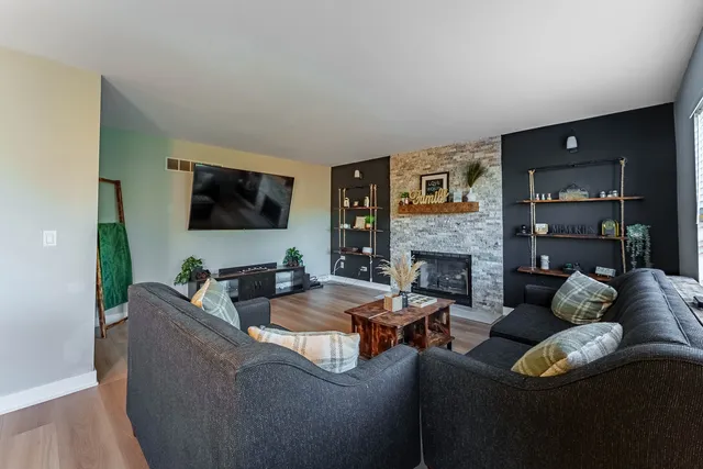 a living room with furniture a flat screen tv and a fireplace