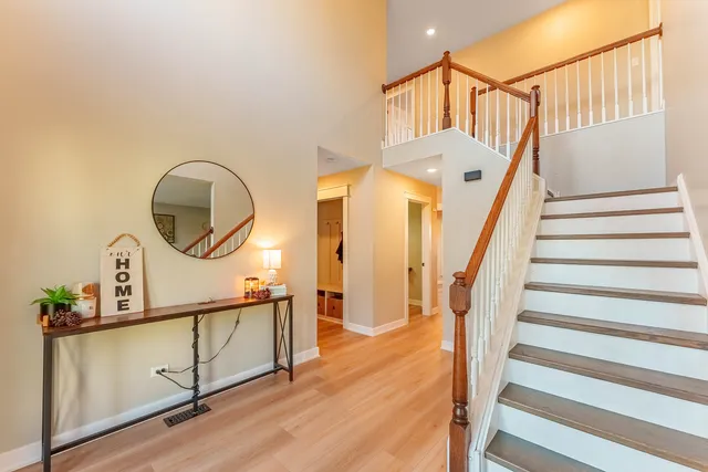 a view of staircase with white walls and a mirror