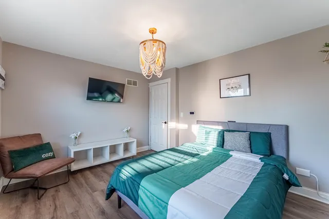 a bedroom with a bed and a chandelier