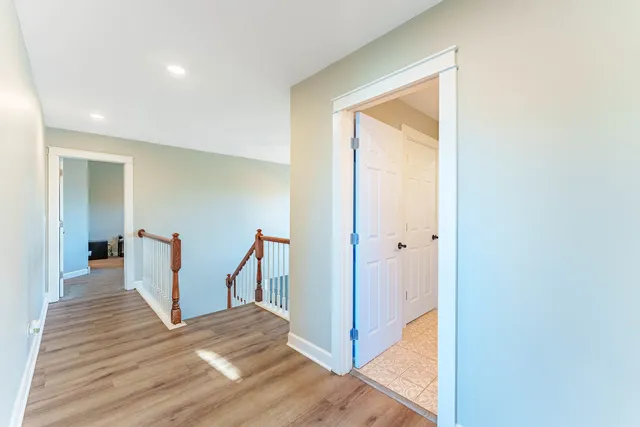 a view of a hallway with wooden floor and entryway