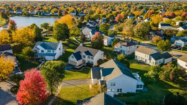 an aerial view of residential houses with outdoor space and lake view