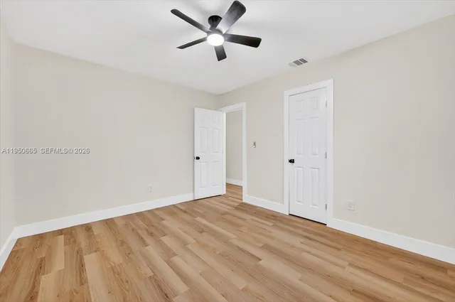 a view of empty room with wooden floor