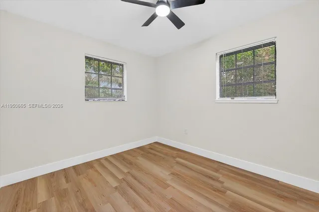 a view of empty room with wooden floor