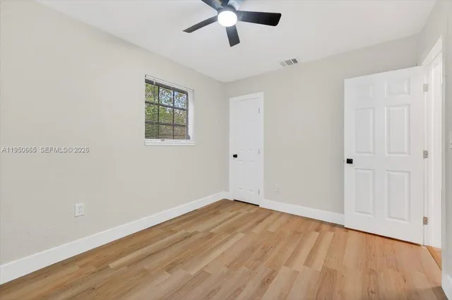 a view of an empty room with wooden floor