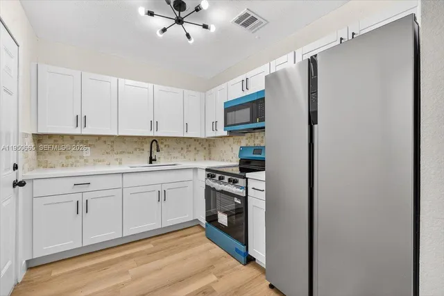 a kitchen with granite countertop white cabinets and white appliances
