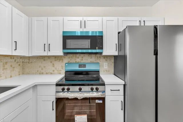 a kitchen with stainless steel appliances white cabinets and a stove