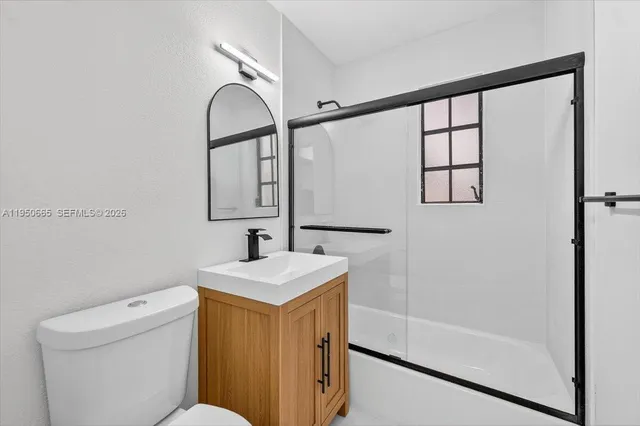 a bathroom with a sink toilet and mirror