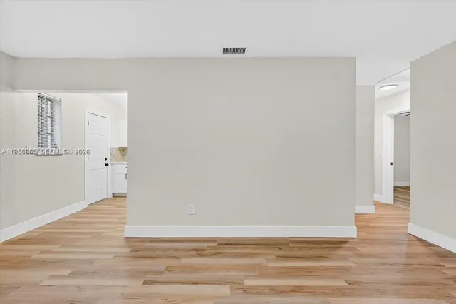 a view of an empty room with wooden floor
