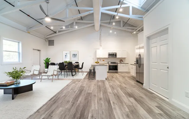 a living room with lots of furniture and kitchen view