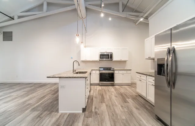 a kitchen with stainless steel appliances a refrigerator sink and stove