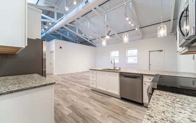 a large kitchen with kitchen island a sink stainless steel appliances and cabinets