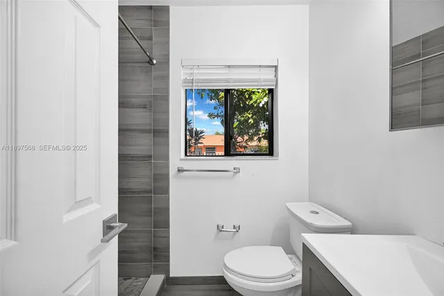 a white toilet sitting next to a bathroom sink