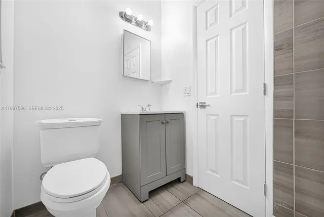 a bathroom with a toilet a sink and mirror