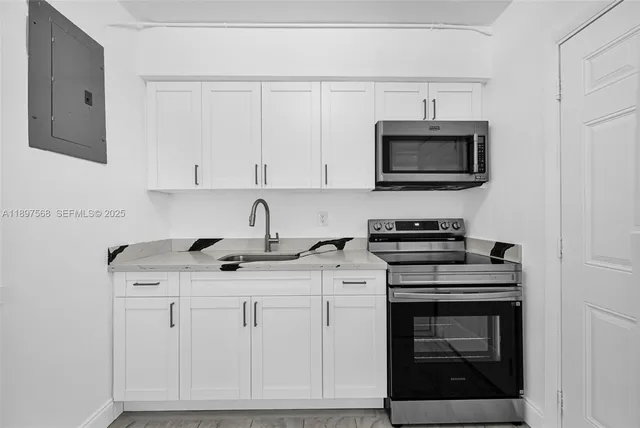 a kitchen with white cabinets stainless steel appliances and sink
