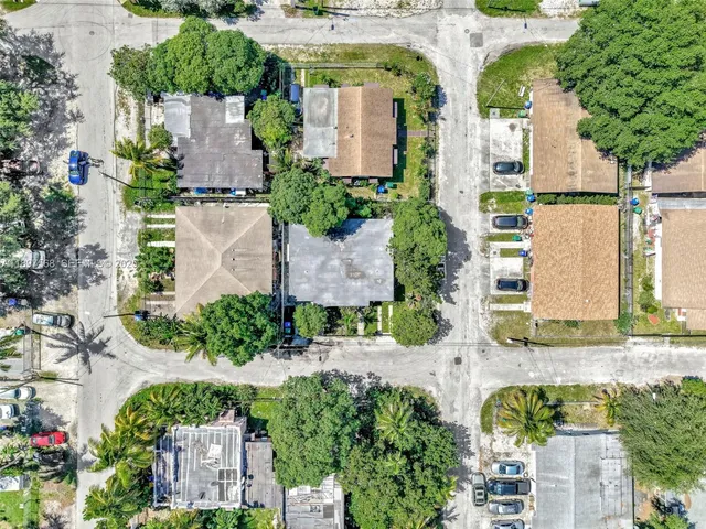 an aerial view of residential houses with outdoor space and trees
