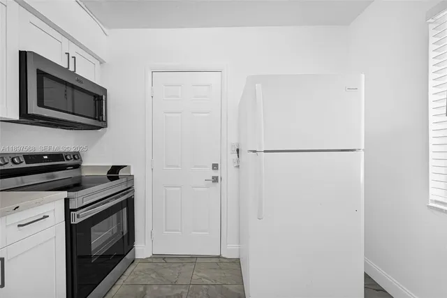 a kitchen with stainless steel appliances granite countertop a refrigerator and a stove top oven