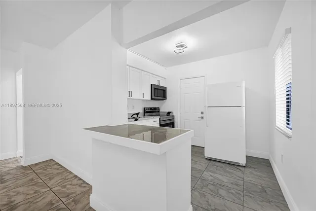 a kitchen with sink cabinets and refrigerator