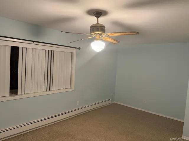 a view of an empty room with chandelier fan