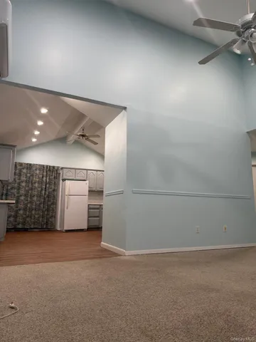 a view of an empty room with a chandelier fan
