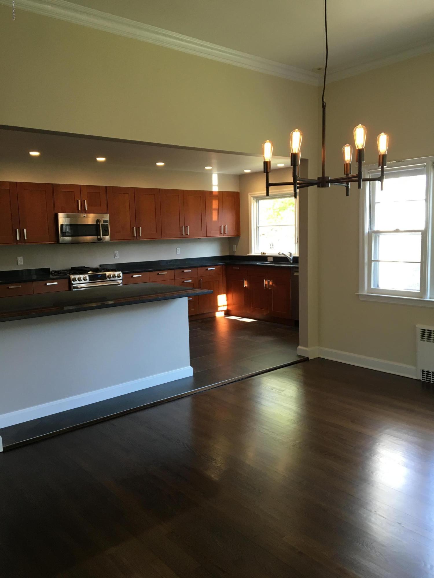 17 Perryridge Road Greenwich, CT 06830 - Photo 5 of 44 a kitchen with stainless steel appliances a sink dishwasher a stove a refrigerator and a dining table with wooden floor
