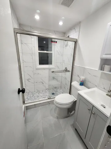a bathroom with a sink a toilet and shower