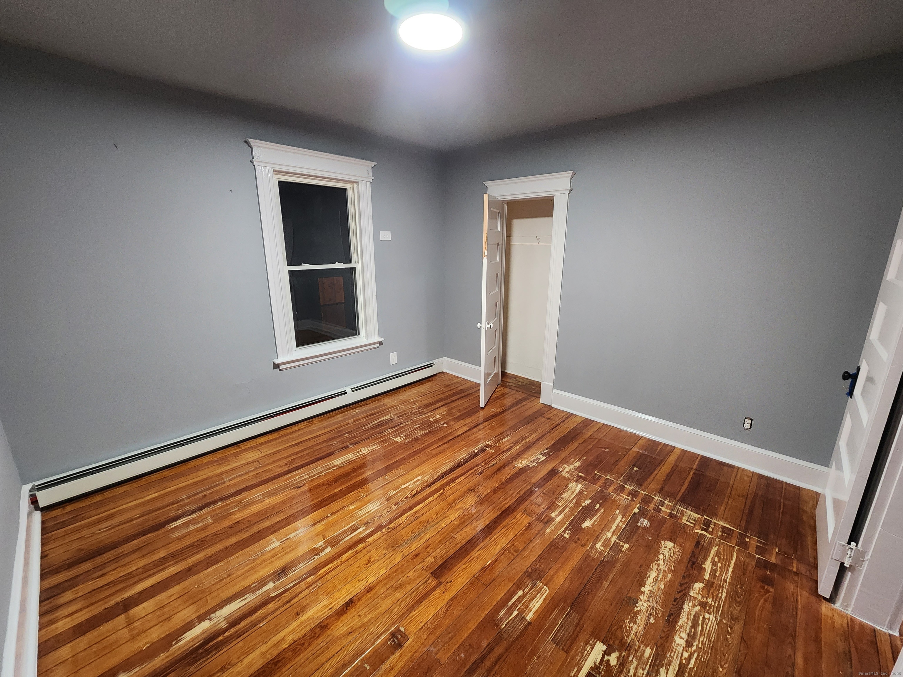 19 Sprague Street Waterbury, CT 06704 - Photo 4 of 12 a view of an empty room with wooden floor and a window