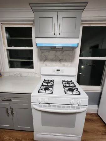 a stove top oven sitting inside of a kitchen