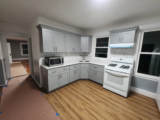 a kitchen with white cabinets and white appliances