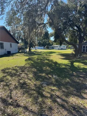 a view of a swimming pool with lawn chairs under an umbrella