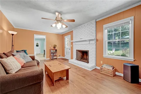 a living room with furniture a fireplace and a window