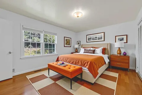 a bed sitting in a bedroom next to a window