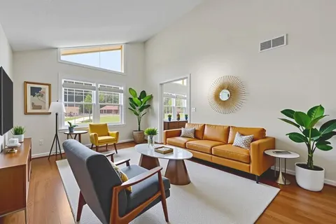 a living room with furniture potted plant and a large window