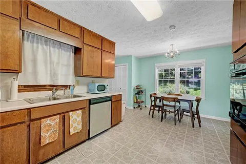 a dining room with stainless steel appliances granite countertop a sink and a refrigerator