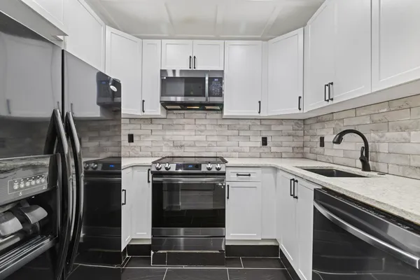 a kitchen with stainless steel appliances a stove sink and cabinets