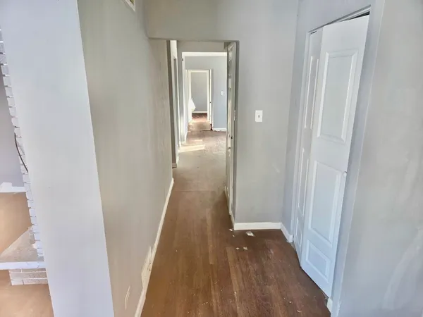 a view of a hallway with wooden floor and entryway