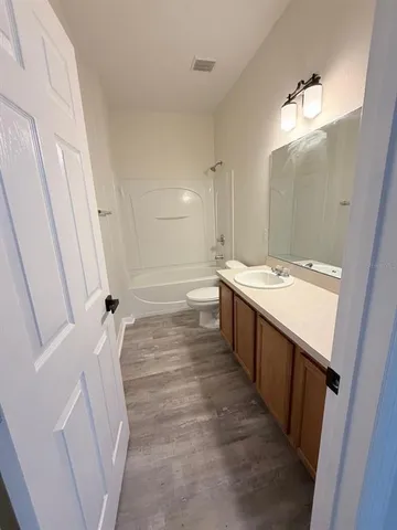 a large white kitchen with a sink a window and stainless steel appliances