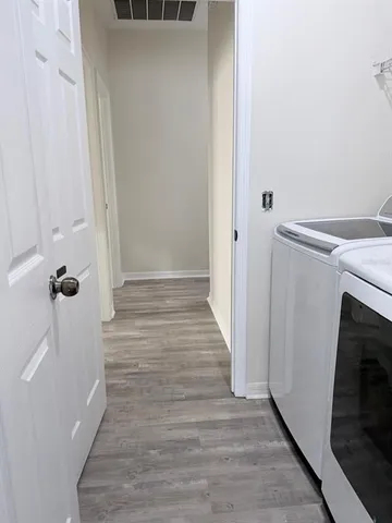 a view of a hallway with wooden floor and staircase