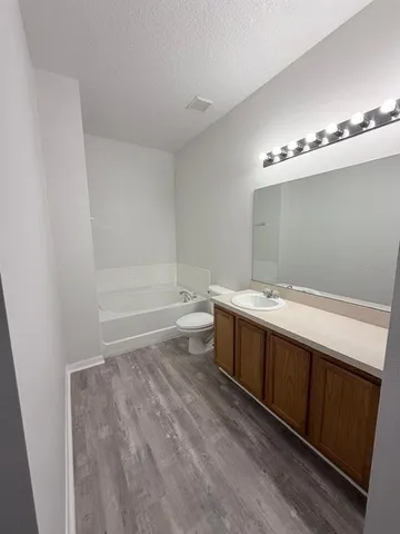 a bathroom with a bathtub sink vanity and toilet