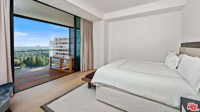 a bed room with a bed and a view of balcony