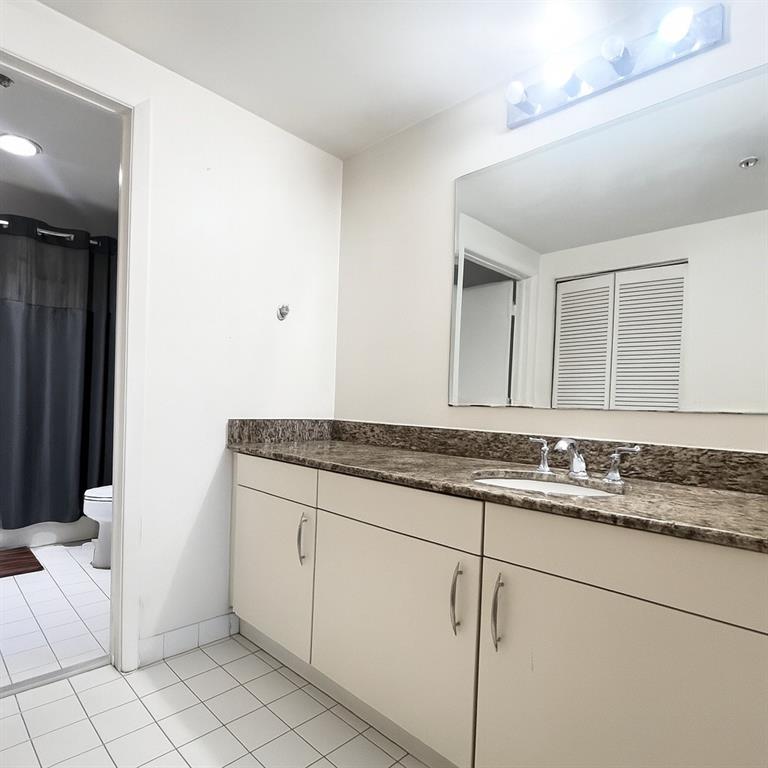 7280 Southwest 90th Street, Unit 304 Miami, FL 33156 - Photo 6 of 13 a bathroom with a granite countertop sink and a mirror