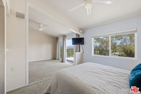 a bedroom with a bed and a large window