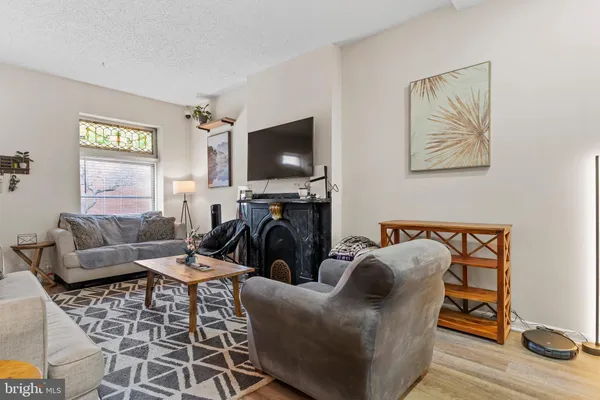 a living room with furniture a flat screen tv and a window