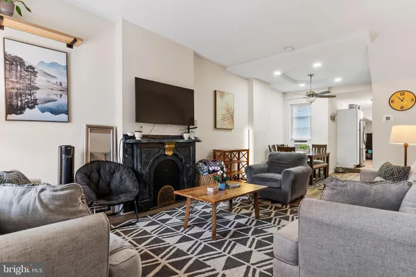 a living room with furniture a flat screen tv and a fireplace