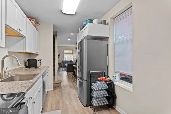 a kitchen with granite countertop a sink appliances and cabinets