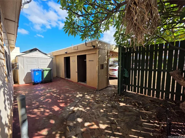 a view of a house with a tree and wooden fence