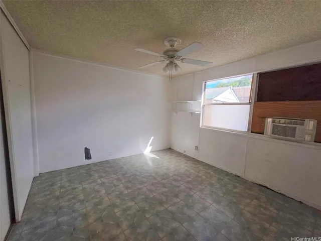 an empty room with windows and fan