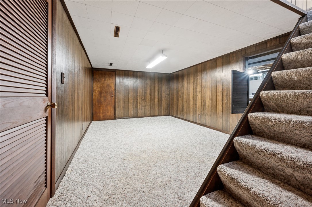 6944 Rolling Ridge Road Northeast Canton, OH 44721 - Photo 17 of 27 Basement rec room with stairs, wood walls, and carpet floors